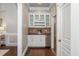 A butler's pantry with granite countertops, tiled backsplash, white cabinetry, and stainless steel beverage cooler at 3505 Watson Rd, Cumming, GA 30028