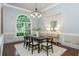 A modern dining room with large arched window, hardwood floors, chandelier, and decorative furnishings at 3505 Watson Rd, Cumming, GA 30028