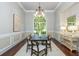 A dining room with modern decor featuring a large arched window, hardwood floors, and a decorative sideboard at 3505 Watson Rd, Cumming, GA 30028