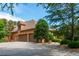 Expansive driveway leading to a beautiful brick home, featuring manicured landscaping and mature trees at 3505 Watson Rd, Cumming, GA 30028