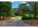 Pathway through beautifully landscaped yard with decorative stones and mature trees at 3505 Watson Rd, Cumming, GA 30028