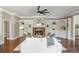 Bright living room features a stone fireplace, built-in bookshelves, ceiling fan and hardwood floors at 3505 Watson Rd, Cumming, GA 30028