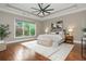 Spacious main bedroom featuring a tray ceiling, fan, and large window with plenty of natural light at 3505 Watson Rd, Cumming, GA 30028