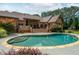Impressive inground kidney-shaped pool with stone surround, complemented by a spacious brick home and deck at 3505 Watson Rd, Cumming, GA 30028