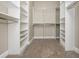 A neutral walk-in closet with carpeted flooring features installed shelving and metal clothes rods at 3505 Watson Rd, Cumming, GA 30028