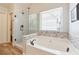 Bright bathroom featuring a soaking tub with mosaic tile surround and a glass-enclosed shower at 6202 Oakdale Ridge Se Ct, Mableton, GA 30126