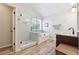 Bright bathroom with a glass-enclosed shower, soaking tub, and granite-topped vanity on wood-look floors at 6202 Oakdale Ridge Se Ct, Mableton, GA 30126