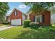 Charming brick home with green lawn and two-car garage on a sunny day at 876 Ashton Oak Cir, Stone Mountain, GA 30083