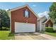 Brick home featuring a two-car garage and well-maintained landscaping at 876 Ashton Oak Cir, Stone Mountain, GA 30083