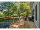 Back deck overlooking wooded backyard with iron table and chairs and comfortable furniture at 2121 Jep Wheeler Rd, Woodstock, GA 30188
