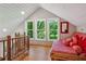 Bedroom with bright natural light, windows viewing trees, wood floors and red daybed at 2121 Jep Wheeler Rd, Woodstock, GA 30188