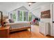 Bedroom with wood floors, neutral walls, windows viewing trees and office desk at 2121 Jep Wheeler Rd, Woodstock, GA 30188