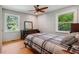 Cozy bedroom featuring a plaid comforter, wood floors, and plenty of natural light from the large windows at 2121 Jep Wheeler Rd, Woodstock, GA 30188