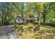 Beautiful home exterior with lush landscaping and a stone accent, offering a serene and inviting curb appeal at 2121 Jep Wheeler Rd, Woodstock, GA 30188
