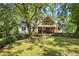 Charming two-story home with a welcoming front porch and lush green lawn surrounded by mature trees at 2121 Jep Wheeler Rd, Woodstock, GA 30188