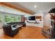 Spacious living room features hardwood floors, a brick fireplace, and a comfortable leather sectional at 2121 Jep Wheeler Rd, Woodstock, GA 30188