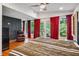 Bedroom with red curtains, wood floors, neutral walls, and many windows offering natural light at 2121 Jep Wheeler Rd, Woodstock, GA 30188