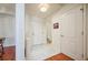 Hallway featuring white walls, tiled flooring, and access to the front door and bathroom at 225 E Ponce De Leon Ave # 310, Decatur, GA 30030