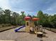 Community playground equipment featuring a slide and climbing structure and surrounded by mature trees at 2873 Shoals Hill Ct, Dacula, GA 30019