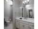 Bathroom with gray walls and white cabinets, toilet, and sink with a large mirror and open doorway at 4673 Jefferson Township Pl, Marietta, GA 30066