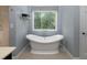 Bright bathroom with a freestanding tub situated under a large window with views of the lush, green outdoors at 4673 Jefferson Township Pl, Marietta, GA 30066