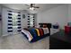 Bedroom featuring a multi-colored striped bed, matching nightstand, and large windows dressed in navy striped curtains at 4673 Jefferson Township Pl, Marietta, GA 30066