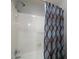Bathroom shower featuring a blue and brown patterned shower curtain and white tile walls at 4673 Jefferson Township Pl, Marietta, GA 30066