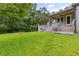 Lush backyard with green lawn, mature trees, and a covered patio at 4847 Lakewood Dr, Acworth, GA 30101