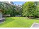 Large backyard featuring a deck, lush lawn, tall trees, and a greenhouse at 4847 Lakewood Dr, Acworth, GA 30101