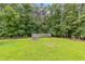 Spacious, green backyard featuring a greenhouse and mature trees at 4847 Lakewood Dr, Acworth, GA 30101