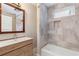 Bathroom with stone-look tile, white fixtures, wooden vanity, and open bathtub at 4847 Lakewood Dr, Acworth, GA 30101