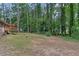 View of the large backyard and deck surrounded by mature trees at 6372 Valley Dale Dr, Riverdale, GA 30274