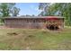 Exterior of home shows the back brick wall with a backyard and a deck with a red umbrella at 6372 Valley Dale Dr, Riverdale, GA 30274