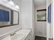 Bathroom featuring a white vanity with a single sink and a framed mirror and a window at 6372 Valley Dale Dr, Riverdale, GA 30274