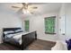 Bedroom featuring a dark wood bed frame, ceiling fan, two windows and wood floors at 6372 Valley Dale Dr, Riverdale, GA 30274