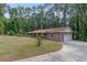 Ranch-style brick home featuring an attached garage, a well-manicured lawn, and mature trees at 6372 Valley Dale Dr, Riverdale, GA 30274