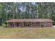 Charming brick home with a covered front porch and well-maintained lawn with mature trees in the background at 6372 Valley Dale Dr, Riverdale, GA 30274