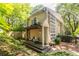 Rear exterior with upper deck and lower patio surrounded by natural, mature landscaping at 1192 Cleburne Ne Ave, Atlanta, GA 30307