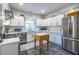 White kitchen featuring stainless steel appliances, white cabinets, tile backsplash and a wood island at 1192 Cleburne Ne Ave, Atlanta, GA 30307