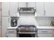 Stainless steel range and hood with white herringbone backsplash and white cabinets at 1192 Cleburne Ne Ave, Atlanta, GA 30307