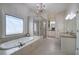Spacious bathroom featuring a glass shower, jacuzzi tub, granite countertops, and elegant chandelier at 2160 Kensington Gates Nw Dr, Kennesaw, GA 30152