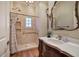 Well-lit bathroom featuring a stone tiled shower, vanity with marble top, and decorative mirror at 2160 Kensington Gates Nw Dr, Kennesaw, GA 30152