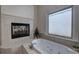 Bathroom with a jacuzzi tub next to a fireplace and a window with natural light at 2160 Kensington Gates Nw Dr, Kennesaw, GA 30152