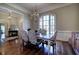 Cozy dining room featuring hardwood floors, a large window, chandelier, and elegant furnishings at 2160 Kensington Gates Nw Dr, Kennesaw, GA 30152