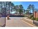 Gated entrance with brick pavers, mature trees, and a manicured lawn, creating a welcoming first impression at 2160 Kensington Gates Nw Dr, Kennesaw, GA 30152