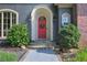Inviting front door with a festive wreath, flanked by lush greenery, stone steps and walkway at 2160 Kensington Gates Nw Dr, Kennesaw, GA 30152