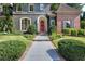 Charming home featuring a red door, gray walkway, manicured bushes, and manicured lawn at 2160 Kensington Gates Nw Dr, Kennesaw, GA 30152