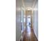 Hallway with hardwood floors, white trim, and doorways leading to rooms with natural light at 2160 Kensington Gates Nw Dr, Kennesaw, GA 30152