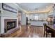 Open kitchen featuring a brick fireplace, hardwood floors, white cabinetry, and a center island at 2160 Kensington Gates Nw Dr, Kennesaw, GA 30152