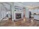 Open kitchen and living area featuring a brick fireplace, hardwood floors, and modern appliances at 2160 Kensington Gates Nw Dr, Kennesaw, GA 30152